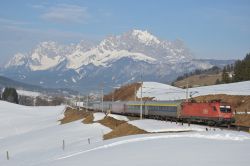 Österreich E-Lok Siemens Taurus Reihe 1116 der ÖBB bei Fieberbrunn im Winter mit Schnee und Kaisergebirge auf der Giselabahn