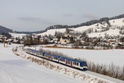 Dieseltriebwagen LINT 54 BRB Bayrische Regiobahn als RB 55 vor dem Ort Schliersee mit Kirche im Winter bei Schnee
