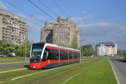 Tram Belgrad / Beograd Serbien Straßenbahn CAF Urbos 3 auf Rasengleis mit Plattenbauten in Neu-Belgrad