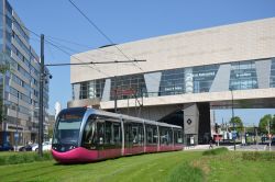 Straßenbahn Alstom Citadis 302 Tram Dijon Frankreich mit Hausdurchfahrt unter einem modernen Gebäude