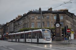 Stadtbahn Edinburgh Tram CAF Urbos 3 mit Uhrenturm bei Regenwetter nahe der Station Haymarket