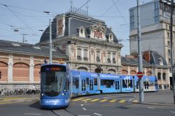 Straßenbahn Genf Geneve Tram Stadler Tango mit Vollwerbung vor historischem Gebäude der Kunsthochschule